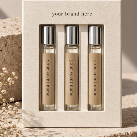 Cream textured perfume sample box with three glass fragrance vials, kraft scent labels, silver caps, and a front display window.