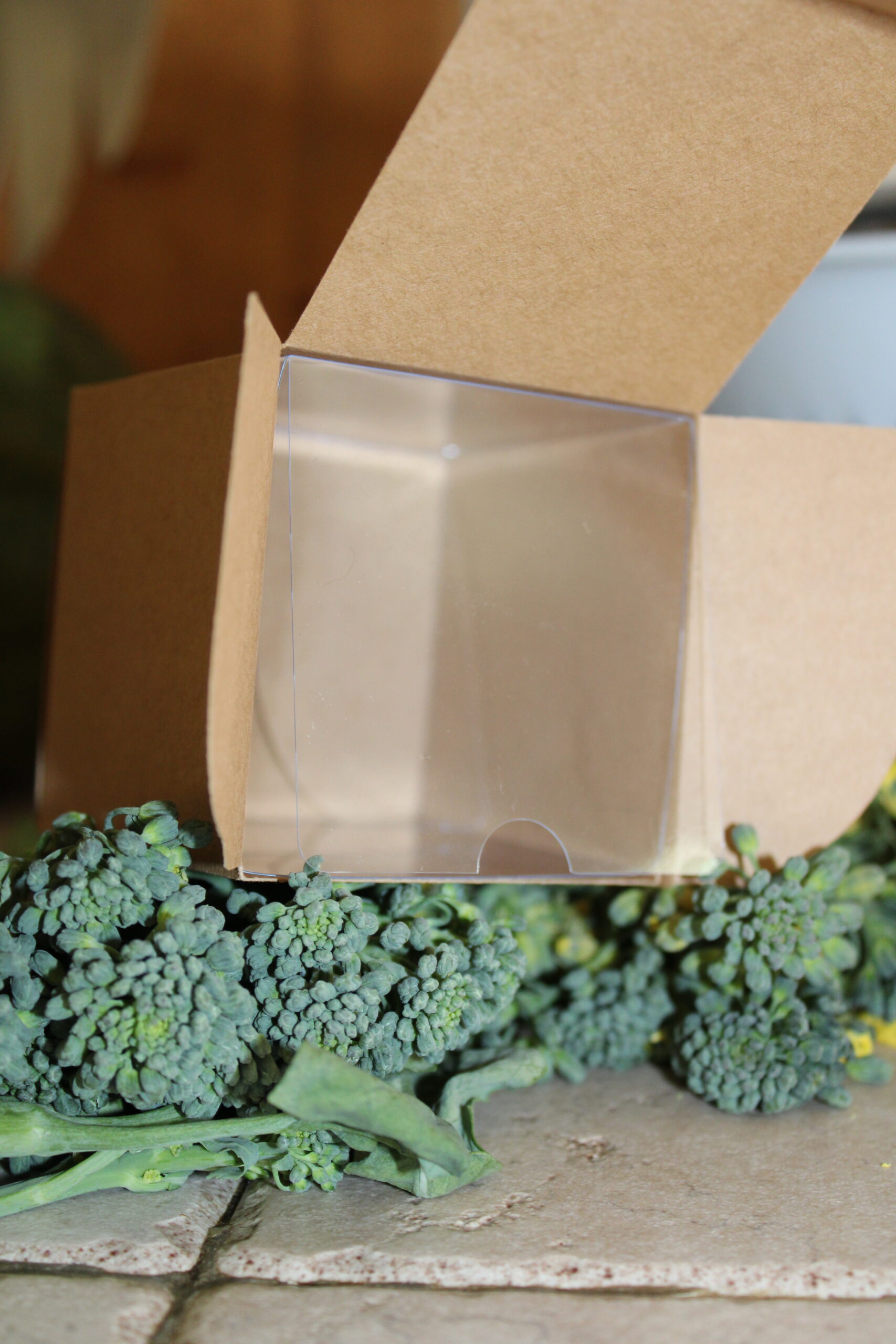Kraft Cream Jar Square Box with a clear plastic insert sitting open on bed of broccoli