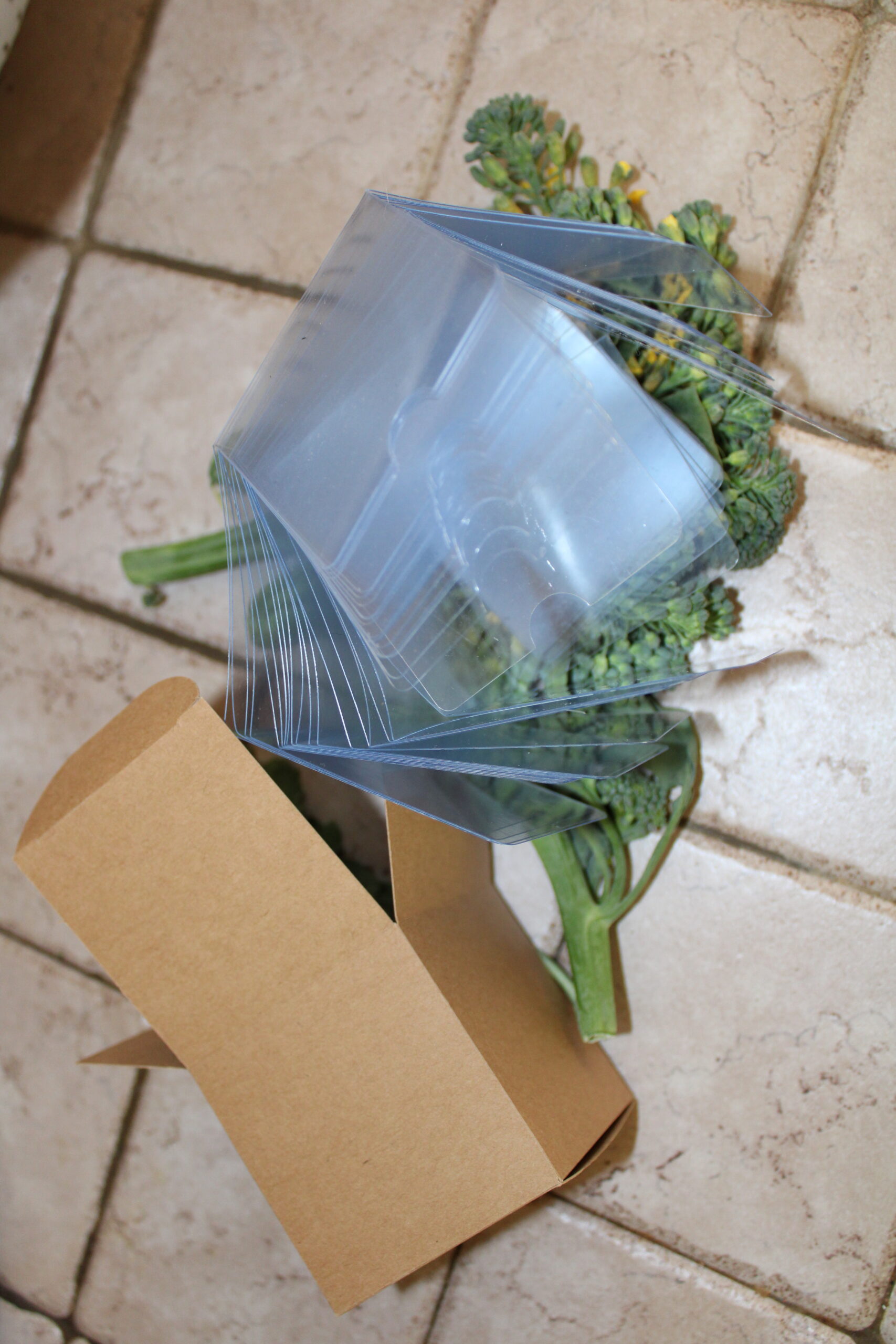 Kraft Cream Jar Square Box with a clear plastic insert sitting open on bed of broccoli