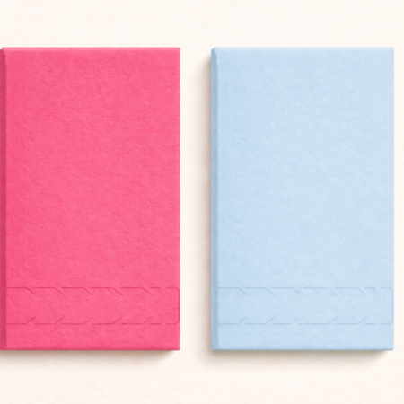 Two textured tear-off soap boxes in vibrant hot pink and soft light blue, displayed side by side on a creamy neutral background, each featuring a subtle perforated chevron tear strip along the lower front panel.