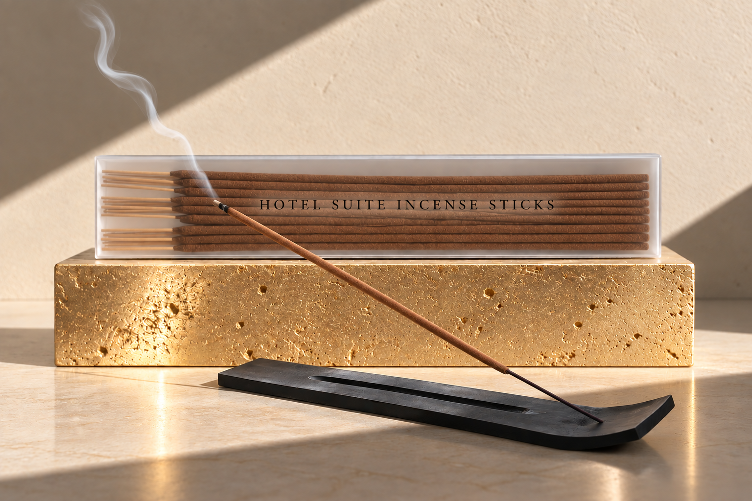 Hotel Suite brown incense sticks displayed on a textured gold pedestal with a burning incense stick in a black holder and warm directional lighting.